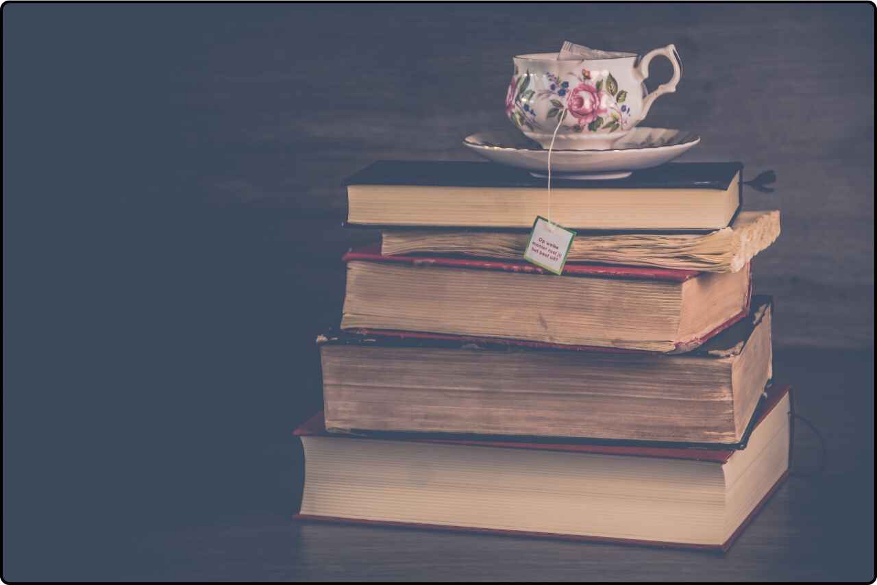 Pile of books with a tea cup placed on top